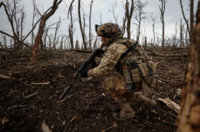 A Ukrainian serviceman checks Russian positions after a fight near the front line city of Bakhmut