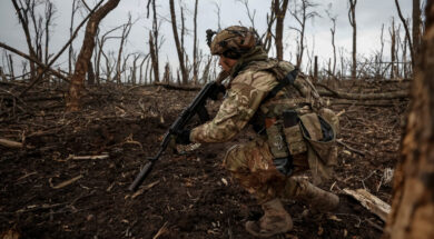 A Ukrainian serviceman checks Russian positions after a fight near the front line city of Bakhmut