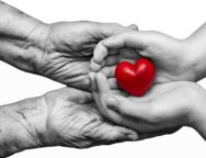 Little,Girl,And,Elderly,Woman,Keeping,Red,Heart,In,Their