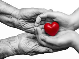 Little,Girl,And,Elderly,Woman,Keeping,Red,Heart,In,Their