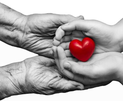 Little,Girl,And,Elderly,Woman,Keeping,Red,Heart,In,Their